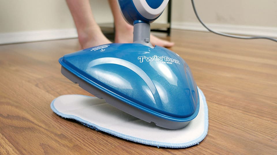 Attaching a cleaning pad to the Twin Tanks steam mop is completed by placing the head on the back of the pad.