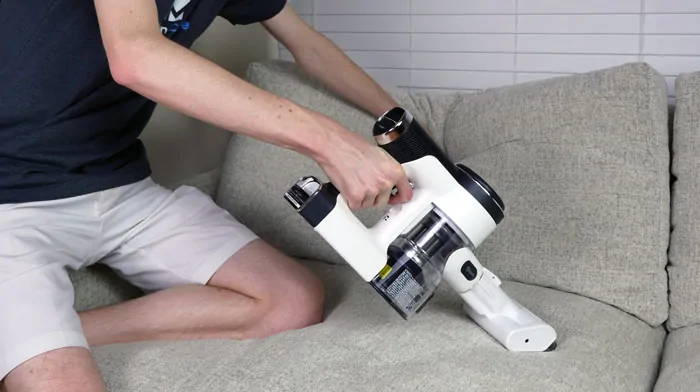 Using the motorized handheld brush attachment for cleaning sofa cushions